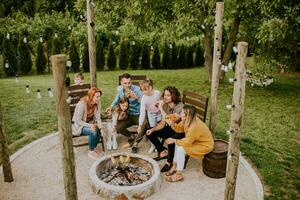 Friends having good time and baking corns in the house backyard photo