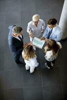 Aerial view at group of business people working together and preparing new project on a meeting in office photo