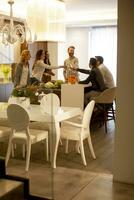 grupo de jóvenes preparando comida, bebiendo vino blanco y pasándolo bien foto