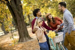 Multiracial young people walking in the autumn park photo