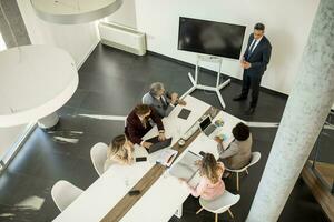 Aerial view at group of business people working together and preparing new project on a meeting in office photo