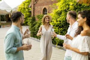 Group of young people cheering and having fun outdoors with drinks photo