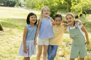 grupo de niños asiáticos y caucásicos divirtiéndose en el parque foto