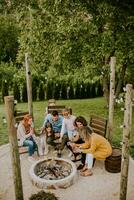 Friends having good time and baking corns in the house backyard photo