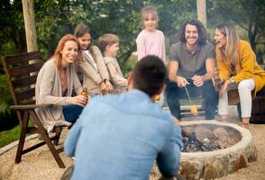 Friends having good time and baking corns in the house backyard photo