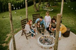 Friends having good time and baking corns in the house backyard photo