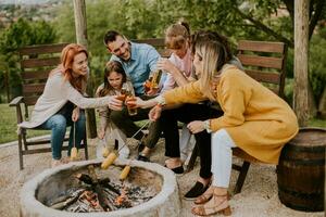 Friends having good time and baking corns in the house backyard photo