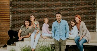 Group of young people and kids having good time in the house backyard photo