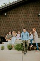 Group of young people and kids having good time in the house backyard photo