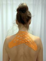 Back treatment with kinesiotaping. Girl with adhesive taping photo
