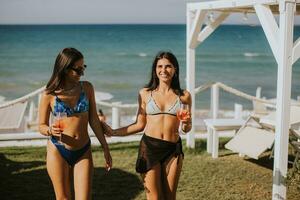 Smiling young women in bikini enjoying vacation on the beach photo