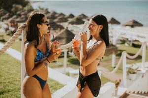 Smiling young women in bikini enjoying vacation on the beach photo