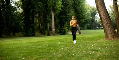 Pretty young woman running in the park photo