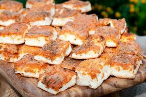 un de madera bandeja con porciones de sfincione en llanura vista. típico focaccia muy popular en palermo, Sicilia. foto