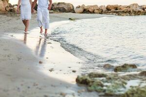 couple walking together along the beach photo