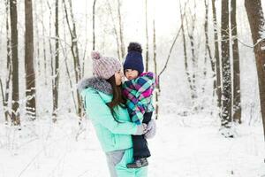 happy family mother and child baby daughter on a winter walk in the woods photo