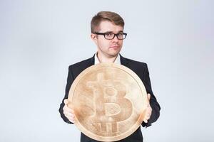 Business man holding big bitcoin in his hands. Cryptocurrency, people, technology, money and future concept photo