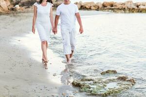 couple walking together along the beach photo