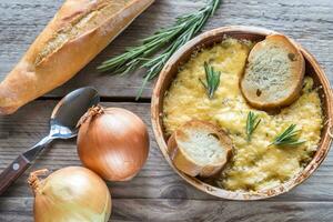 Bowl of onion soup on the wooden table photo
