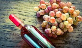 Glass of rose wine with bunch of grape photo