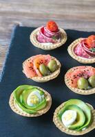 Tartlets with different fillings on the stone board photo