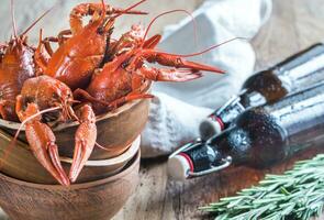 Bowl of boiled crayfish with bottles of beer photo