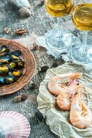 Seafood with two glasses of white wine on the wooden table photo