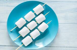 Marshmallow skewers on the plate photo