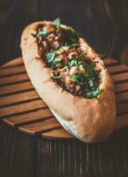 Hot dog bun stuffed with meatballs photo