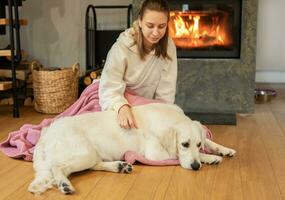 Woman sitting with dog near fireplace photo