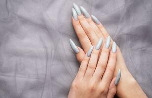 Grey nails on grey lace background. photo