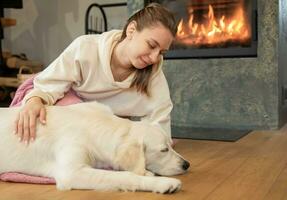 Woman sitting with dog near fireplace photo