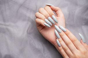 Grey nails on grey lace background. photo