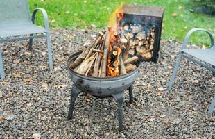 Fire pit and burning fire in a garden photo