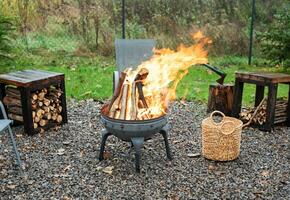 Fire pit and burning fire in a garden photo