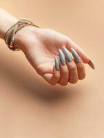 mujer mano con gris uña polaco foto