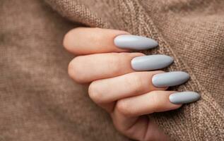 Woman's hand with grey nail polish photo