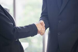 Business people shaking hands, Young man and woman shaking hands in the office photo