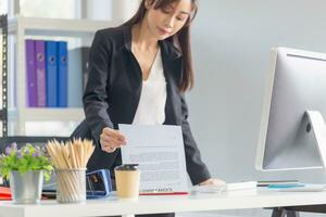 Young busy business woman manager working at the office, lawyer or company employee checking financial documents report working in office photo