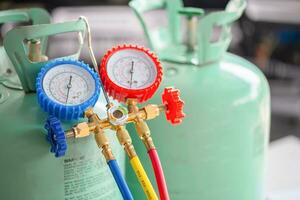 Manifold tool gauge bucket refrigerant applies to car air conditioning with blurred technician repairman check car air conditioning system refrigerant recharge, Car Air Conditioning Repair photo