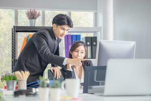 Business people discussing work and using computer screen in modern office, man and woman working and brainstorming in workplace photo