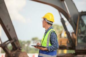 Engineer checking project at the building site, Man in hardhat with digital tablet at infrastructure construction site photo