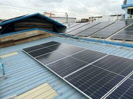 Photovoltaic power on the roof. Solar photovoltaic panels on sunny sky background. Save the planet concept. Green energy concept. Solar energy industry photo