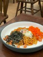 Ham and shrimp eggs Spaghetti Japanese style cooked top on with seaweed and soft boiled egg is on wooden background. photo