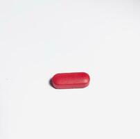 Red tablet pill medication isolated on white background.One single medicine photo