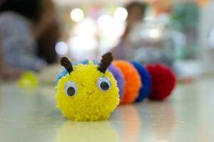 Handmade colorful worm doll and blurred background. photo