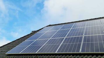 Solar panels producing clean energy on a roof of a residential house video