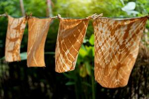 Dyed batik cloth hanging in the outdoor garden. photo