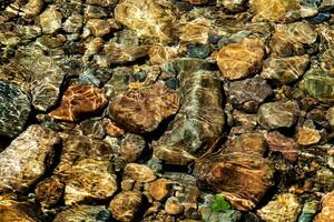 Clear water in the river and stone texture photo