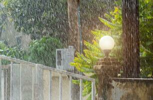 Summer rain storms fall on home and there is a strong wind photo